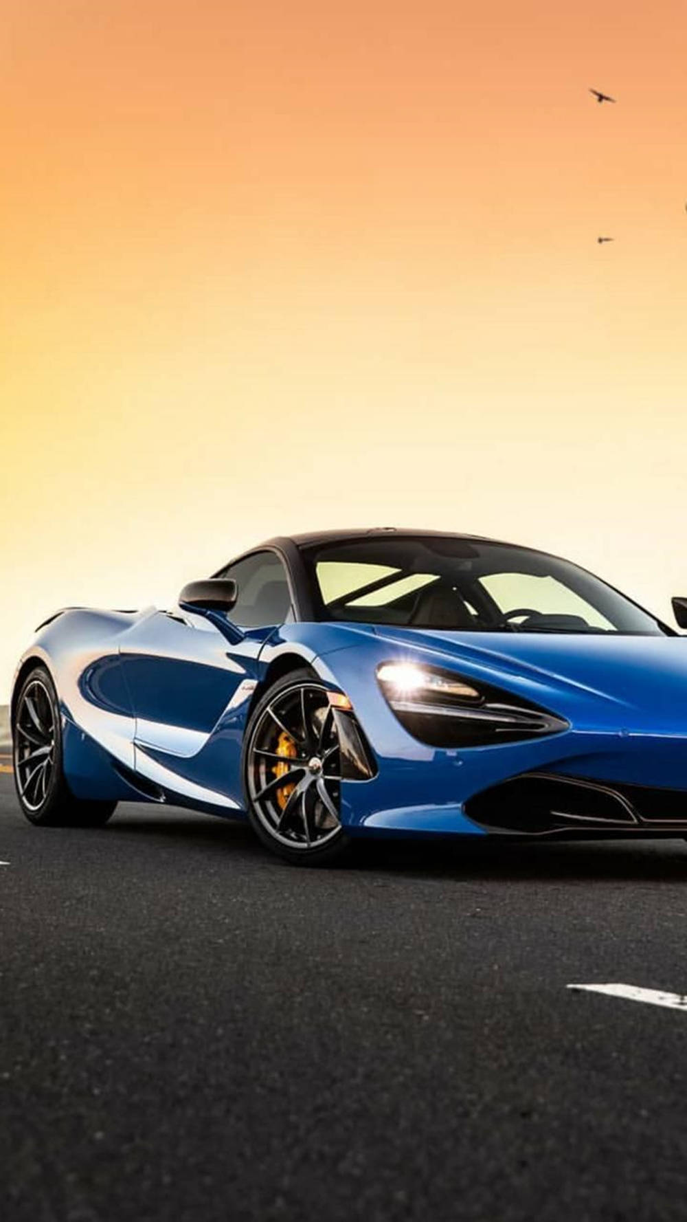 سيارة ماكلارين 720S زرقاء تحت غروب الشمس خلفية