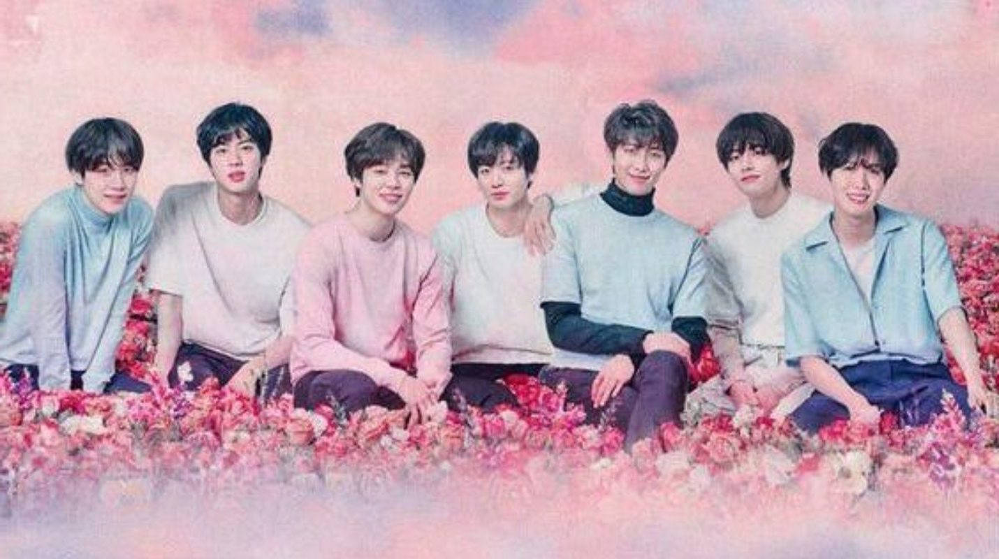 فرقة BTS اللطيفة في حقل زهور وردي خلفية