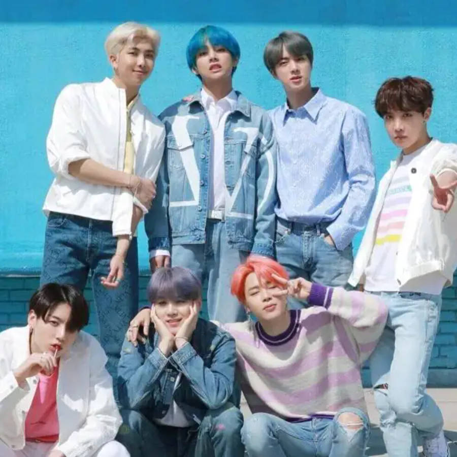 فرقة BTS اللطيفة تتألق معًا أمام جدار أزرق خلفية