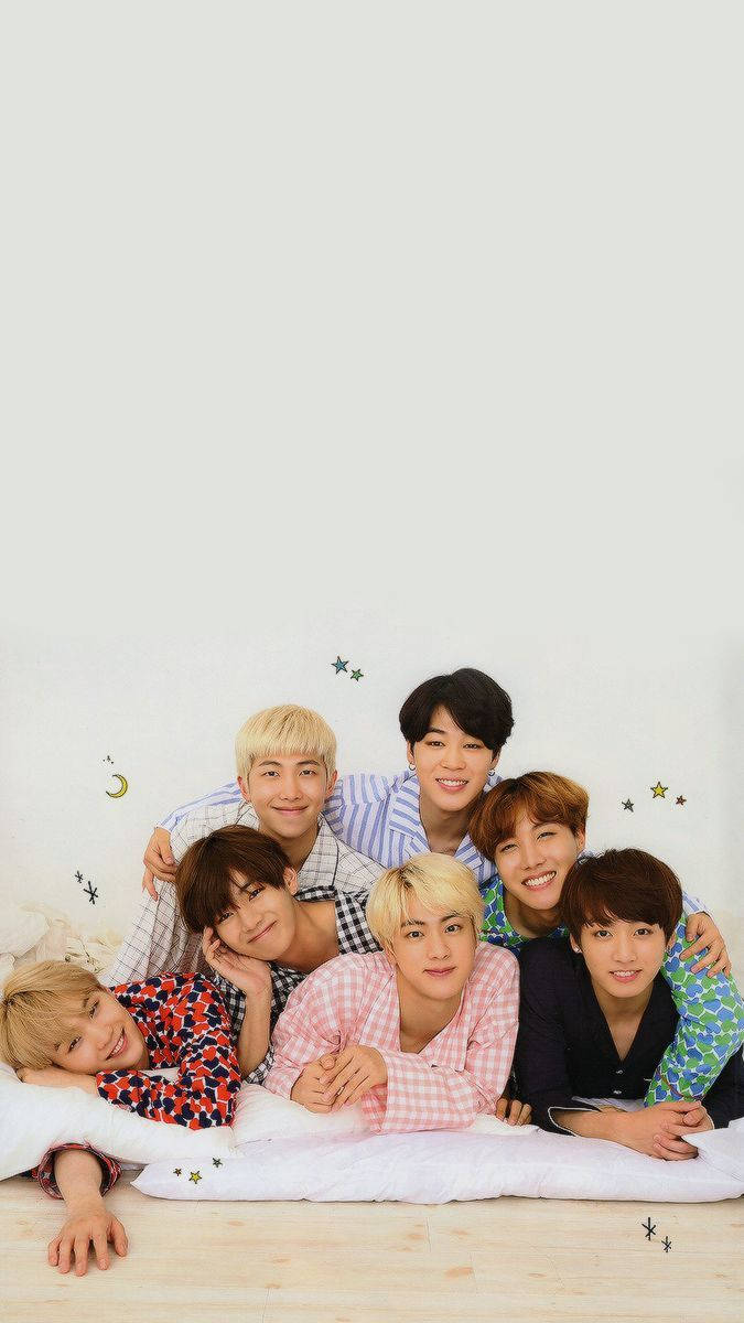 BTS مستلقون معاً على السرير يبتسمون خلفية