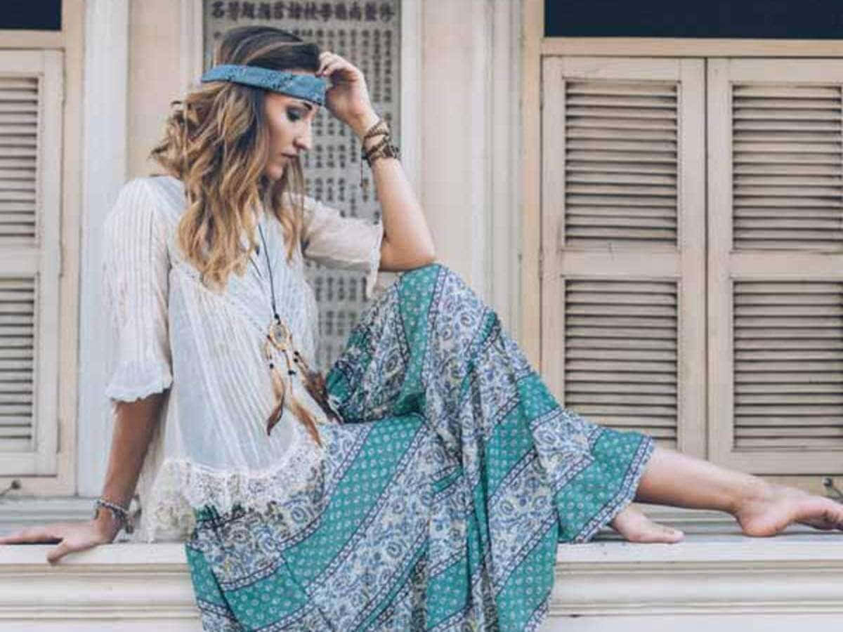 امرأة ترتدي تنورة طويلة وعصابة رأس تجلس على حافة خلفية