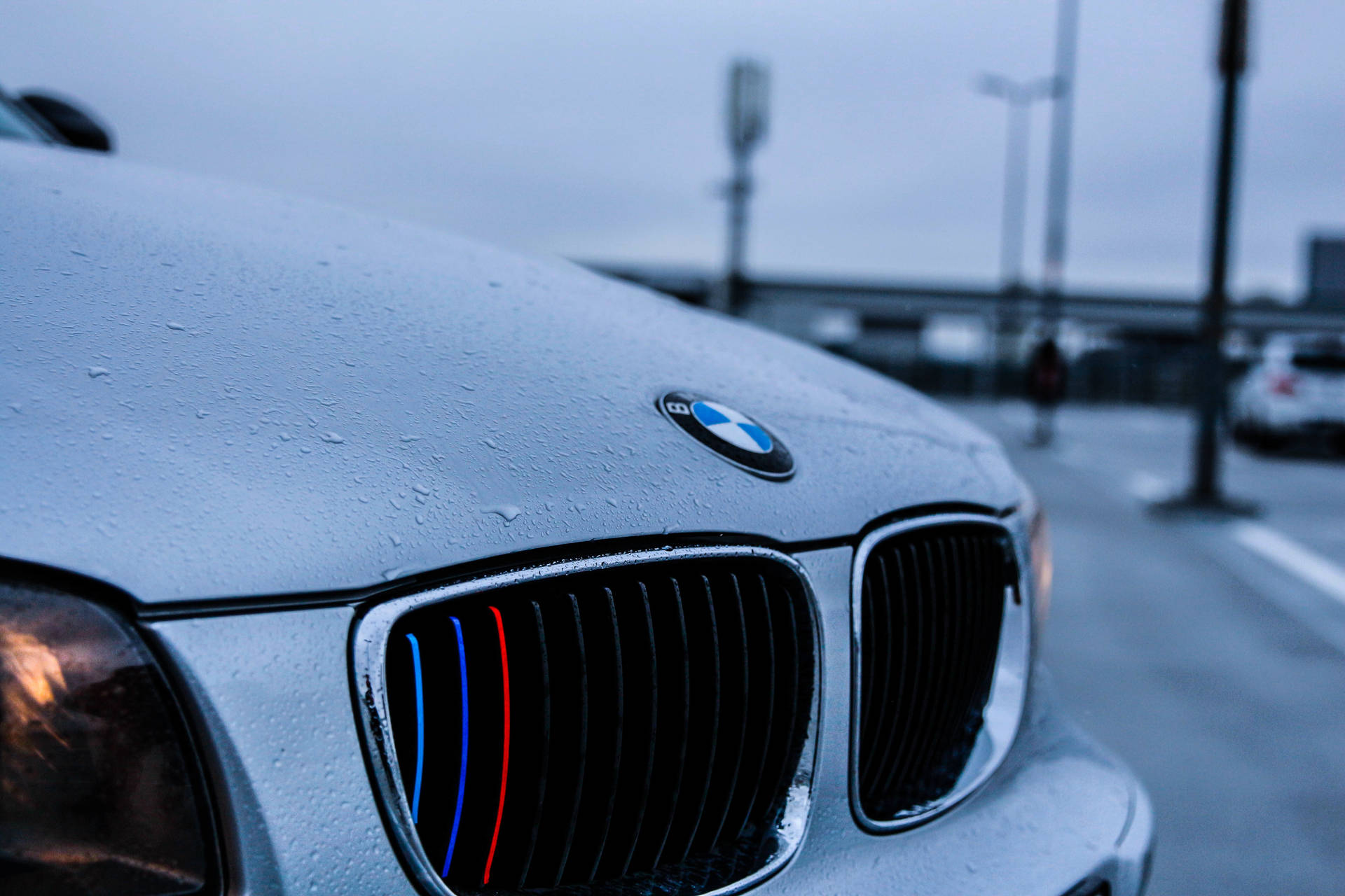 خلفية مقربة لغطاء محرك سيارة BMW بيضاء مع قطرات مطر