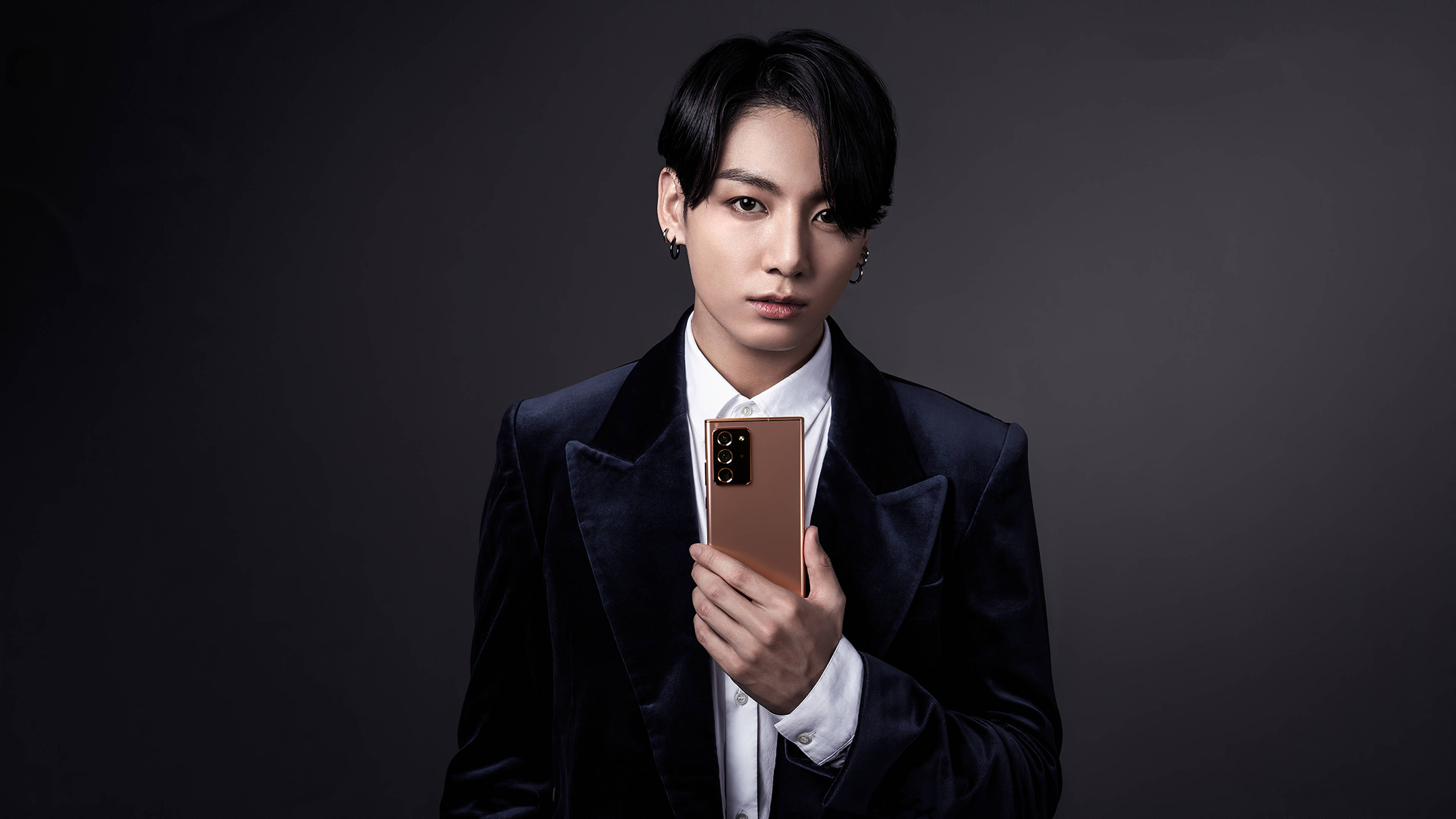 جونغكوك من BTS يعرض هاتفًا بأناقة خلفية