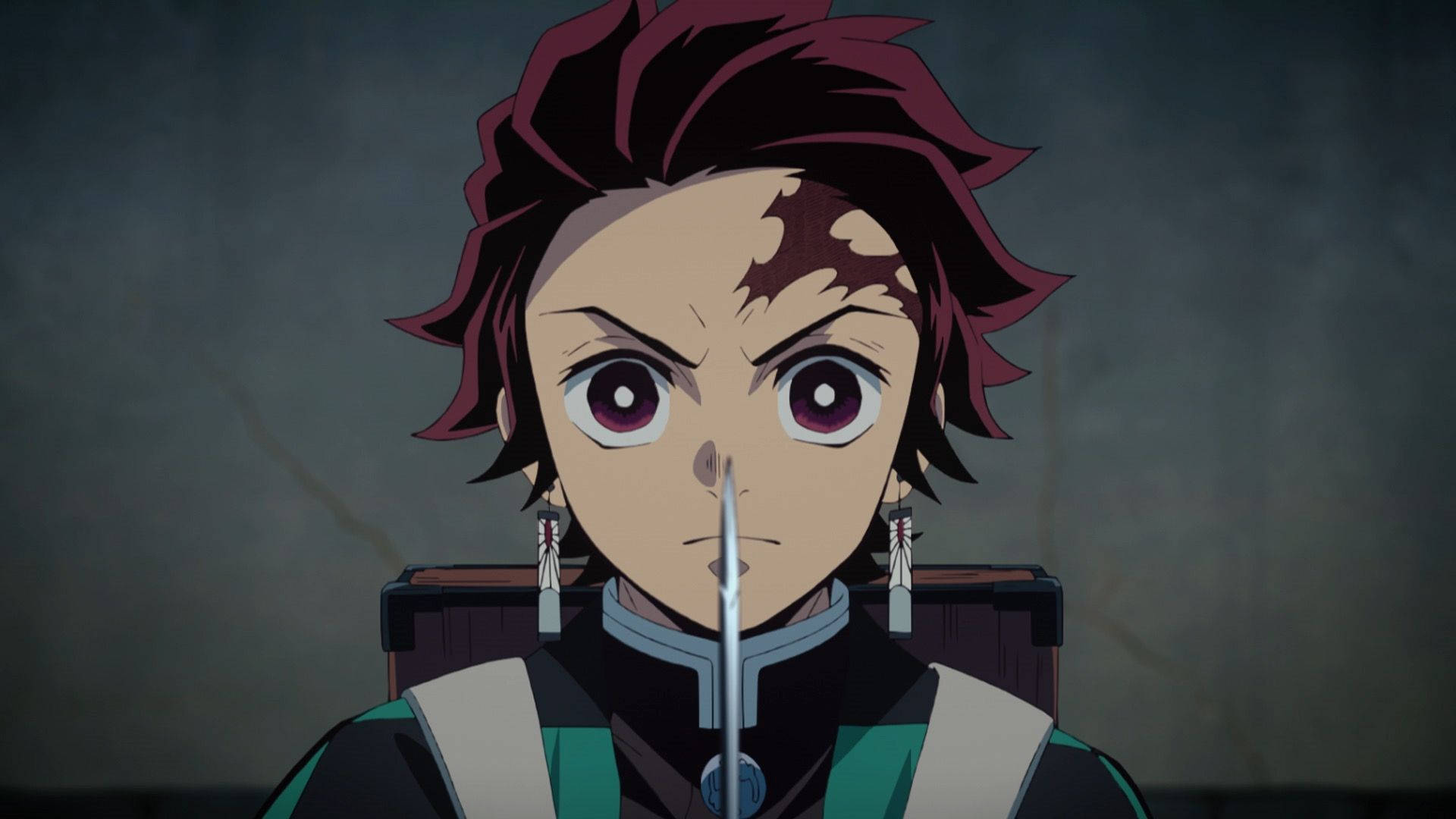 خلفية Demon Slayer لصورة مقربة لوجه كامادو تانجيرو وهو يمسك سيفه.
