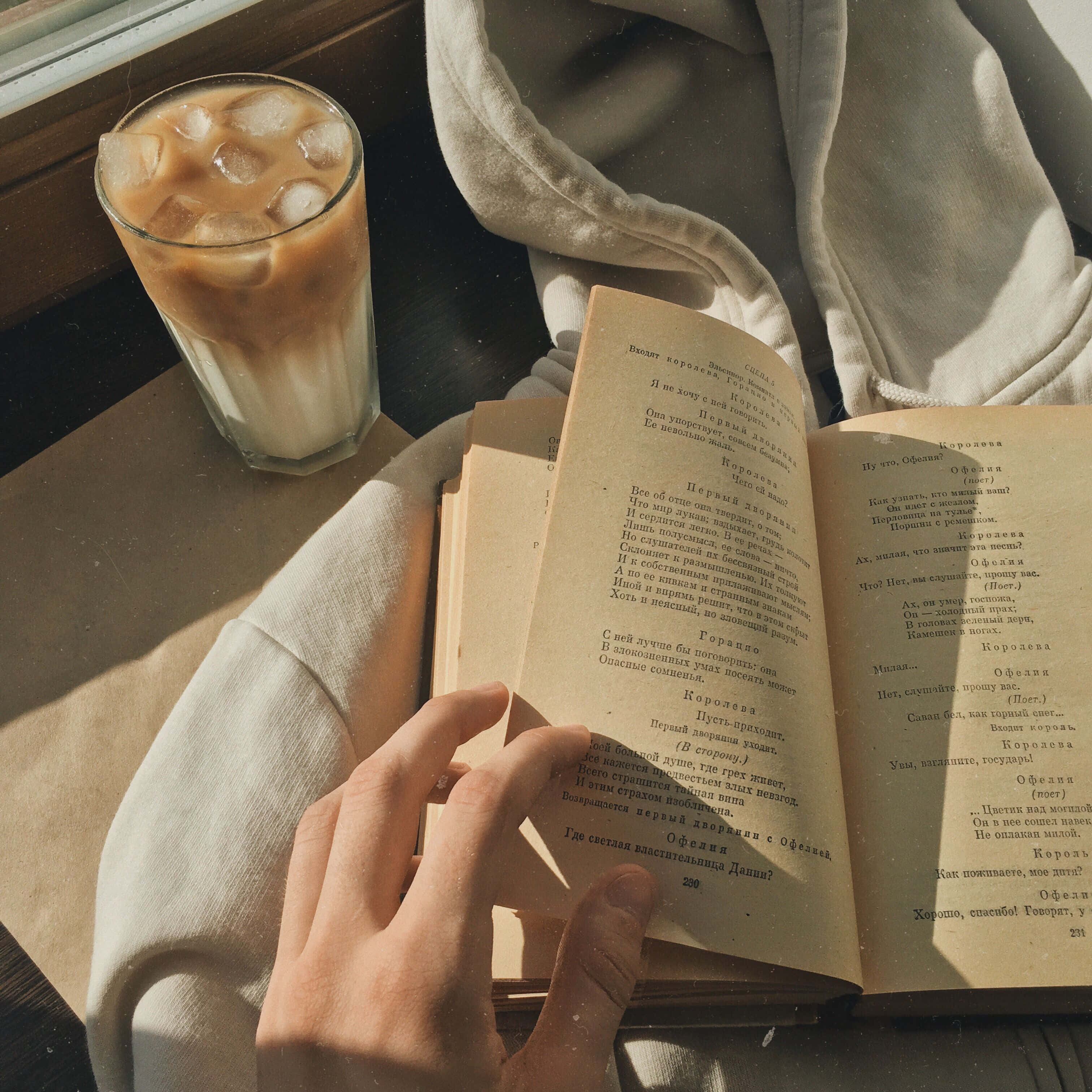 شخص يقرأ كتابًا مع فنجان قهوة خلفية