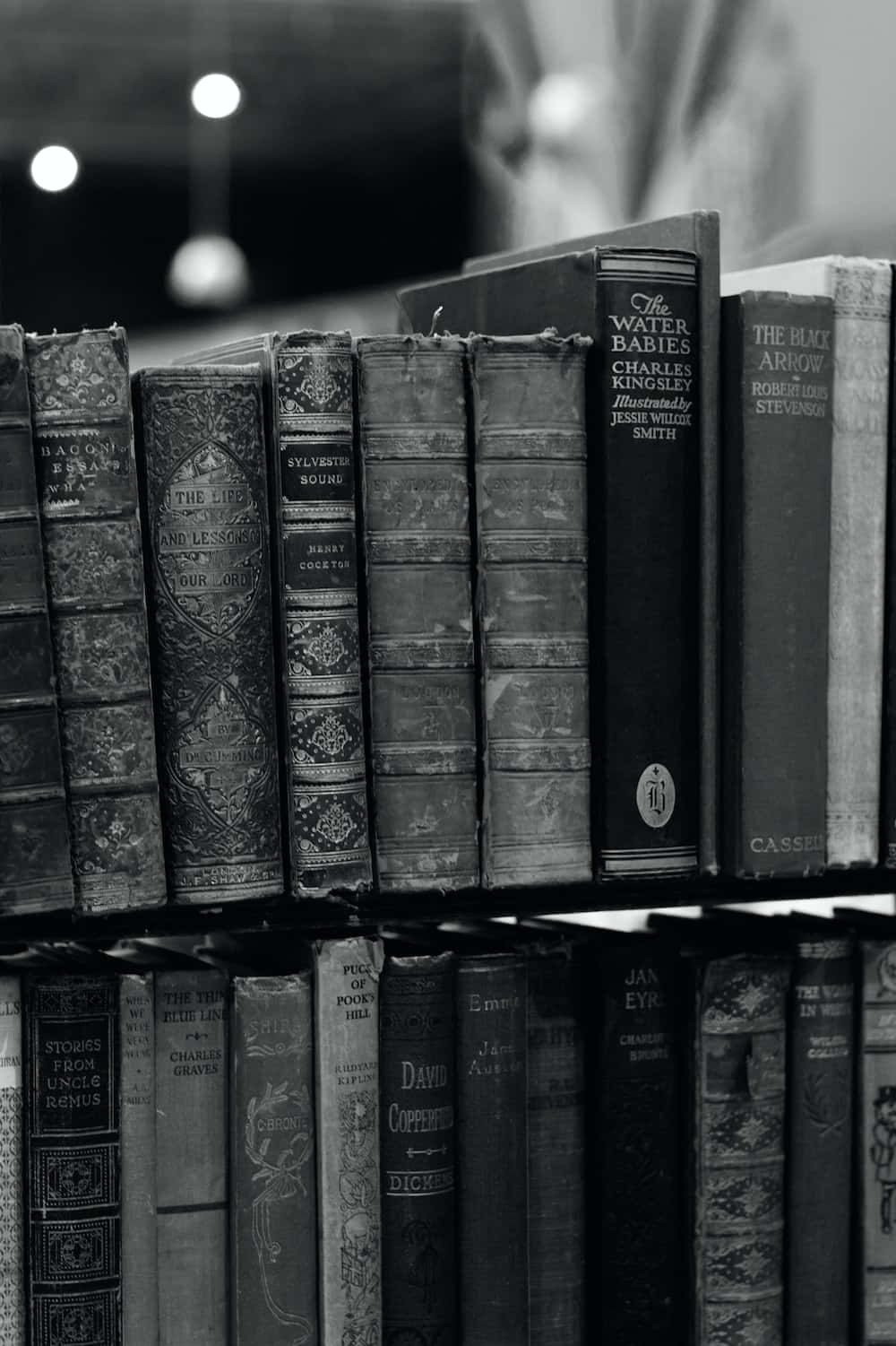 صورة أبيض وأسود لكتب على رف خلفية