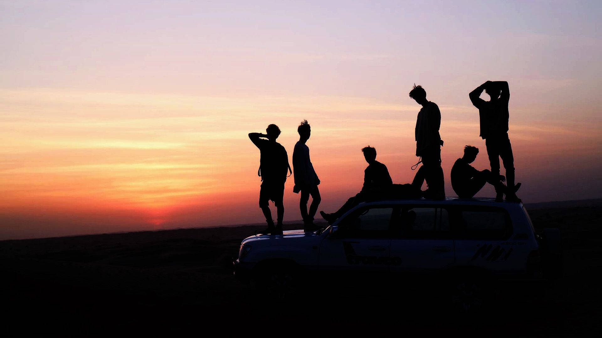 صورة جماعية لفرقة BTS عند غروب الشمس خلفية