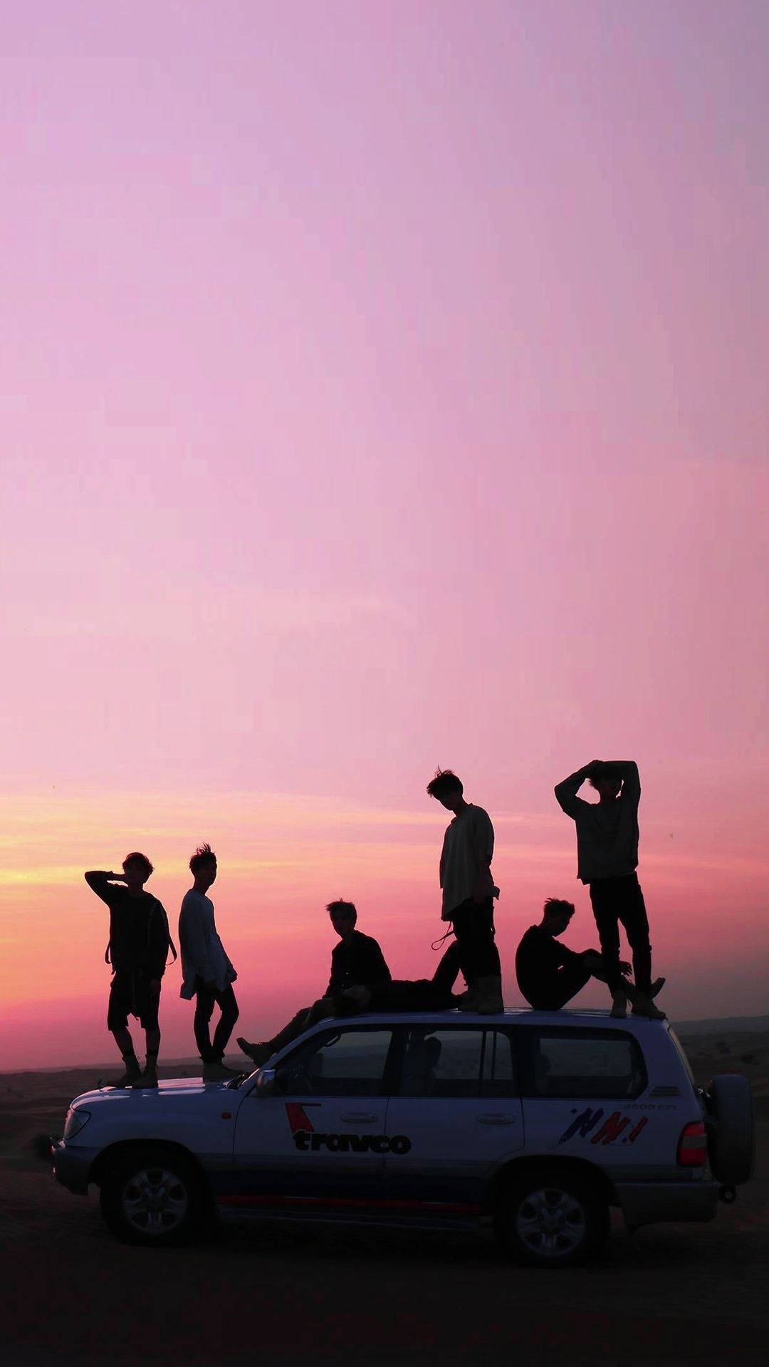 صورة ظلية جمالية لفرقة BTS تحت سماء وردية خلفية
