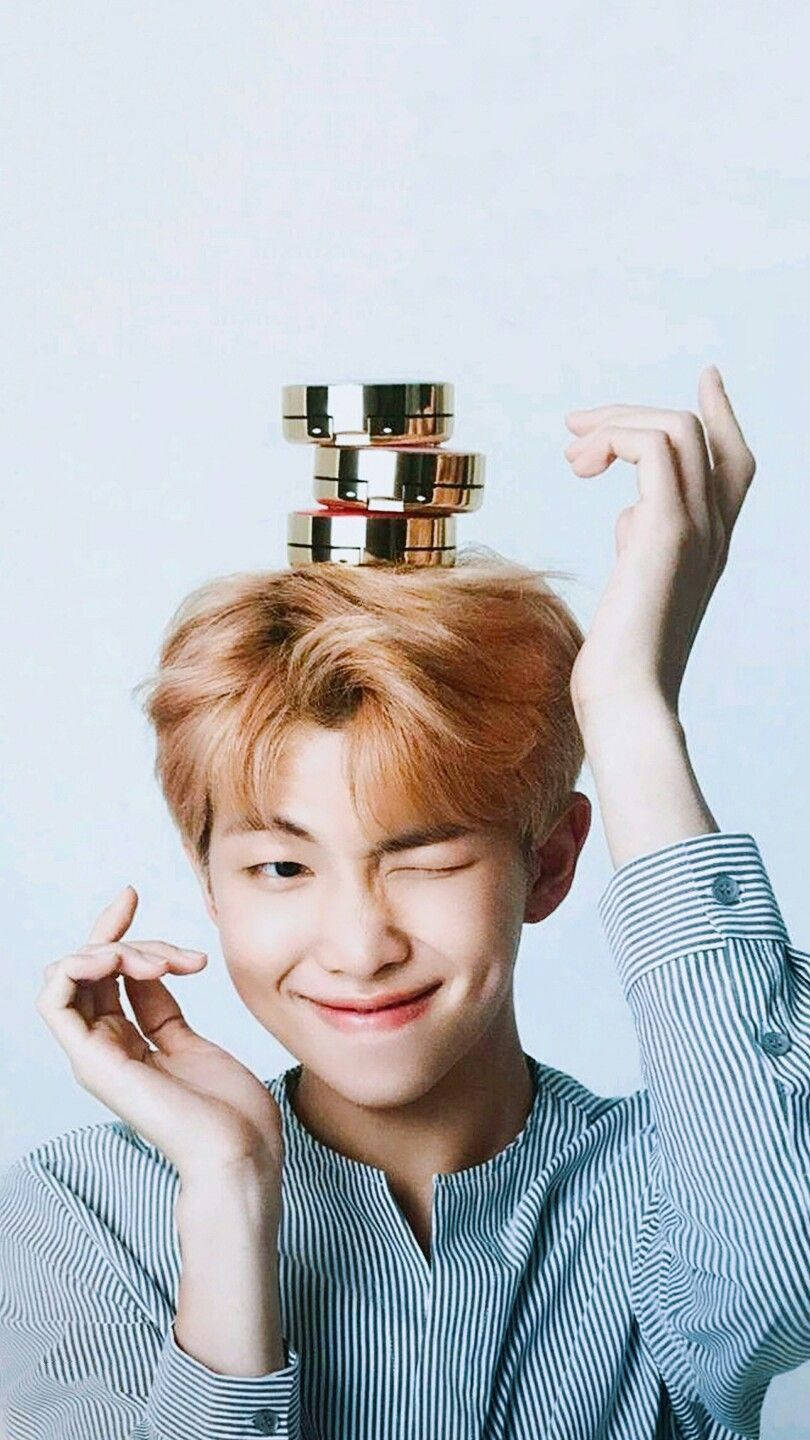 عضو BTS RM اللطيف مع علب البودرة على رأسه خلفية