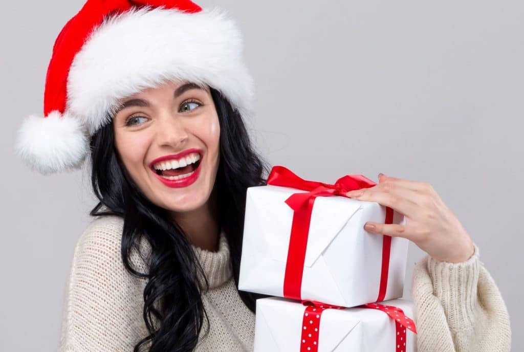 فتاة جميلة تحمل هدايا عيد الميلاد خلفية