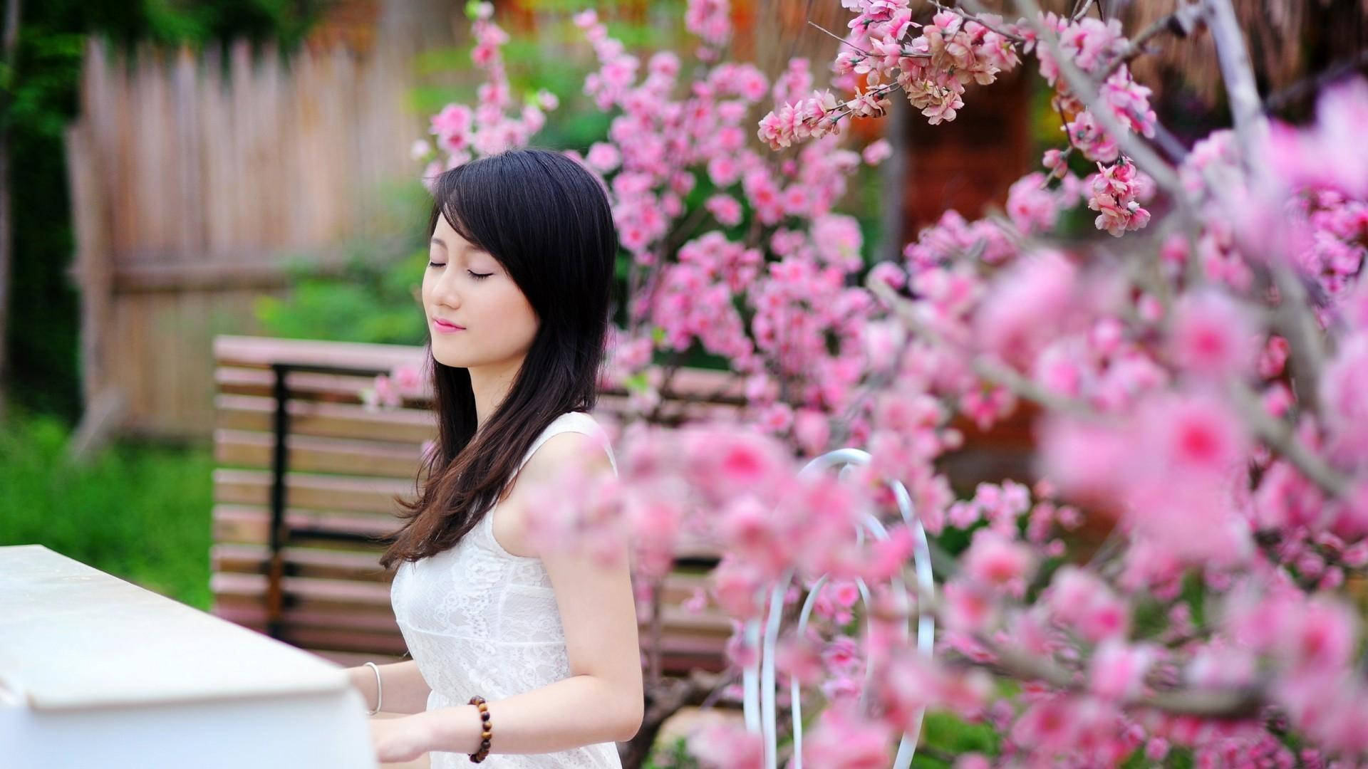 فتاة يابانية تعزف على البيانو في حديقة الورود الوردية خلفية