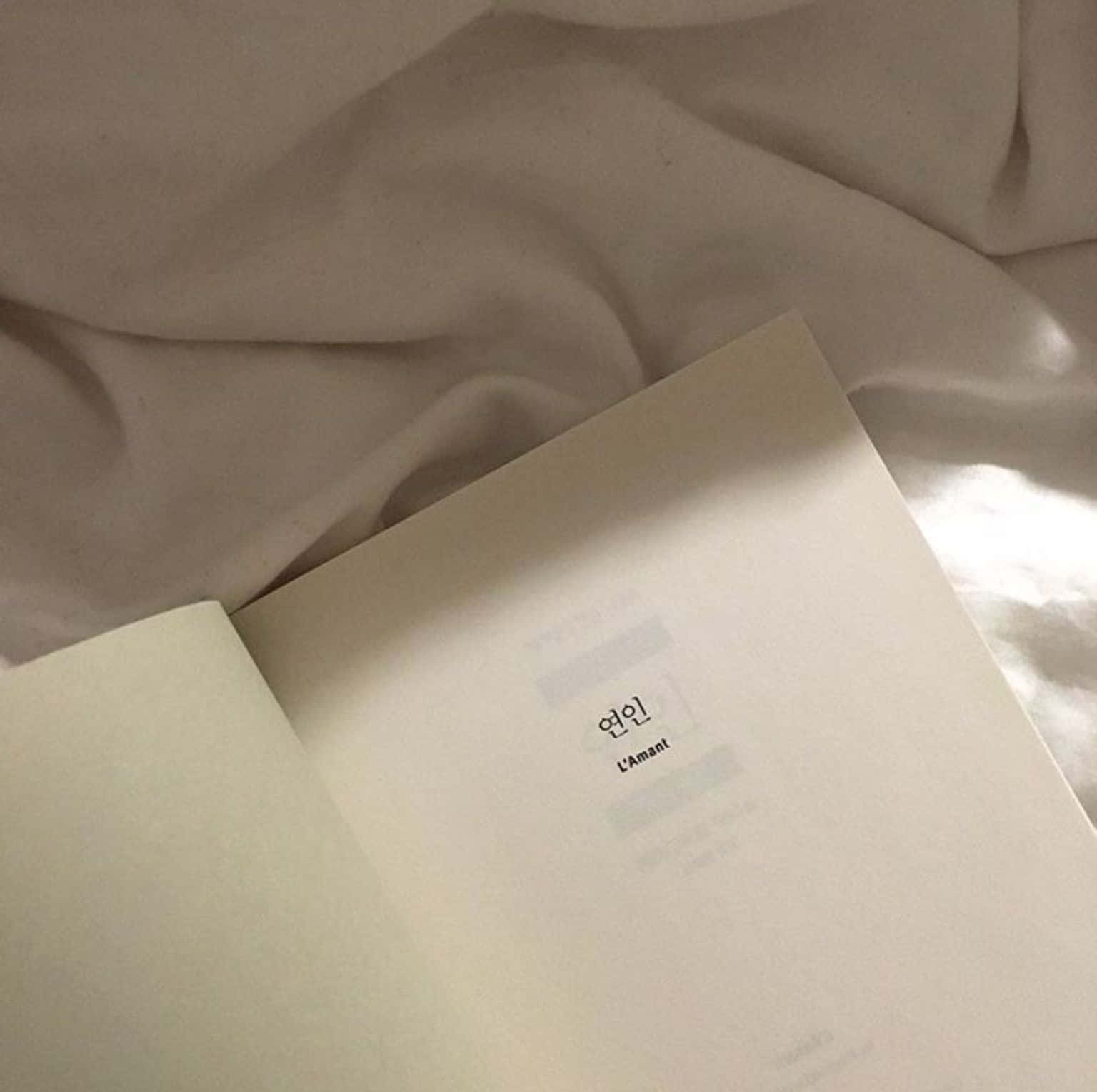 كتاب بغلاف أبيض على سرير خلفية