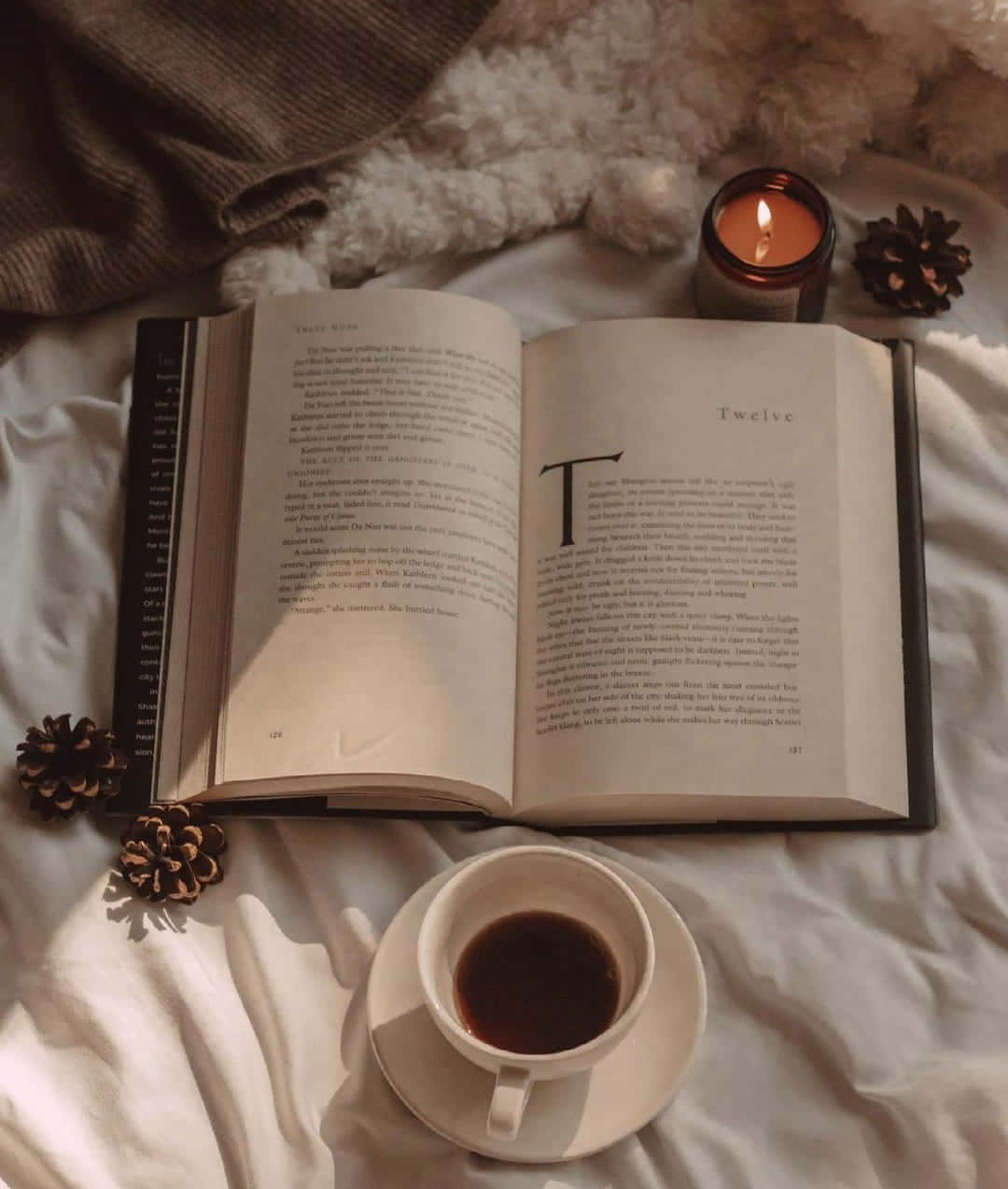 كتاب، شمعة، وفنجان قهوة على السرير خلفية