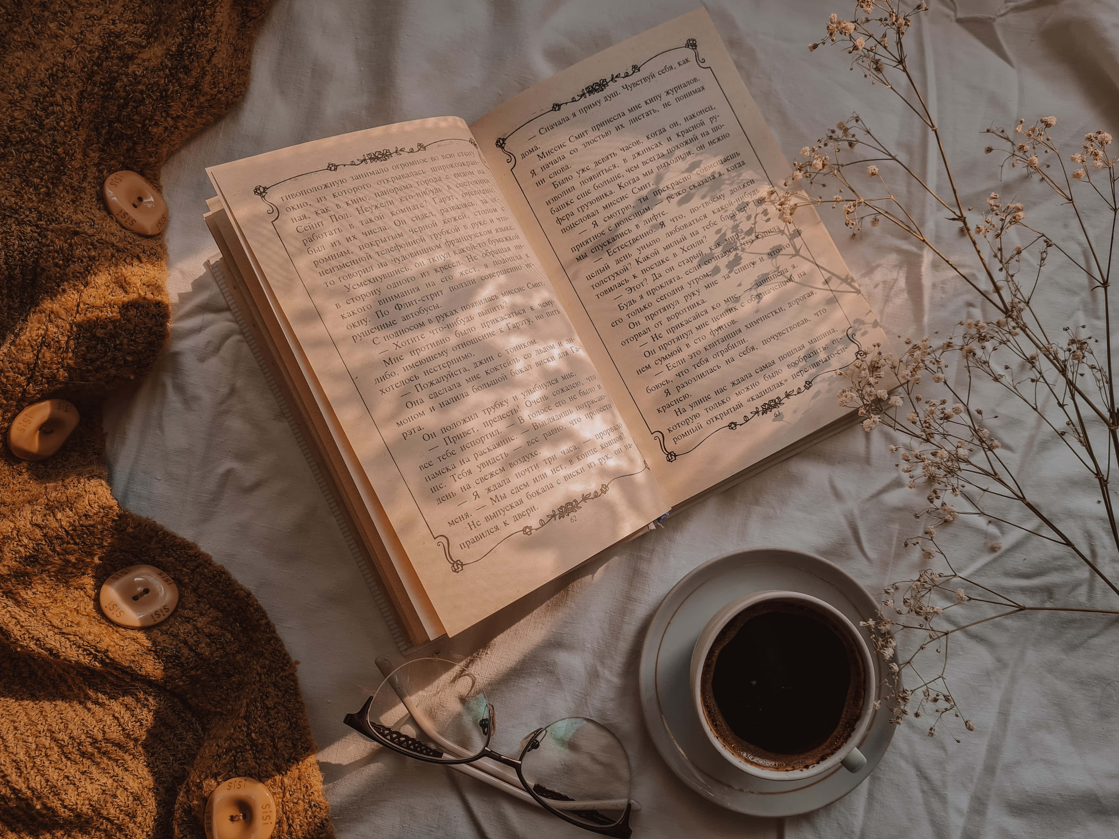 كتاب ونظارات وقهوة على سرير خلفية