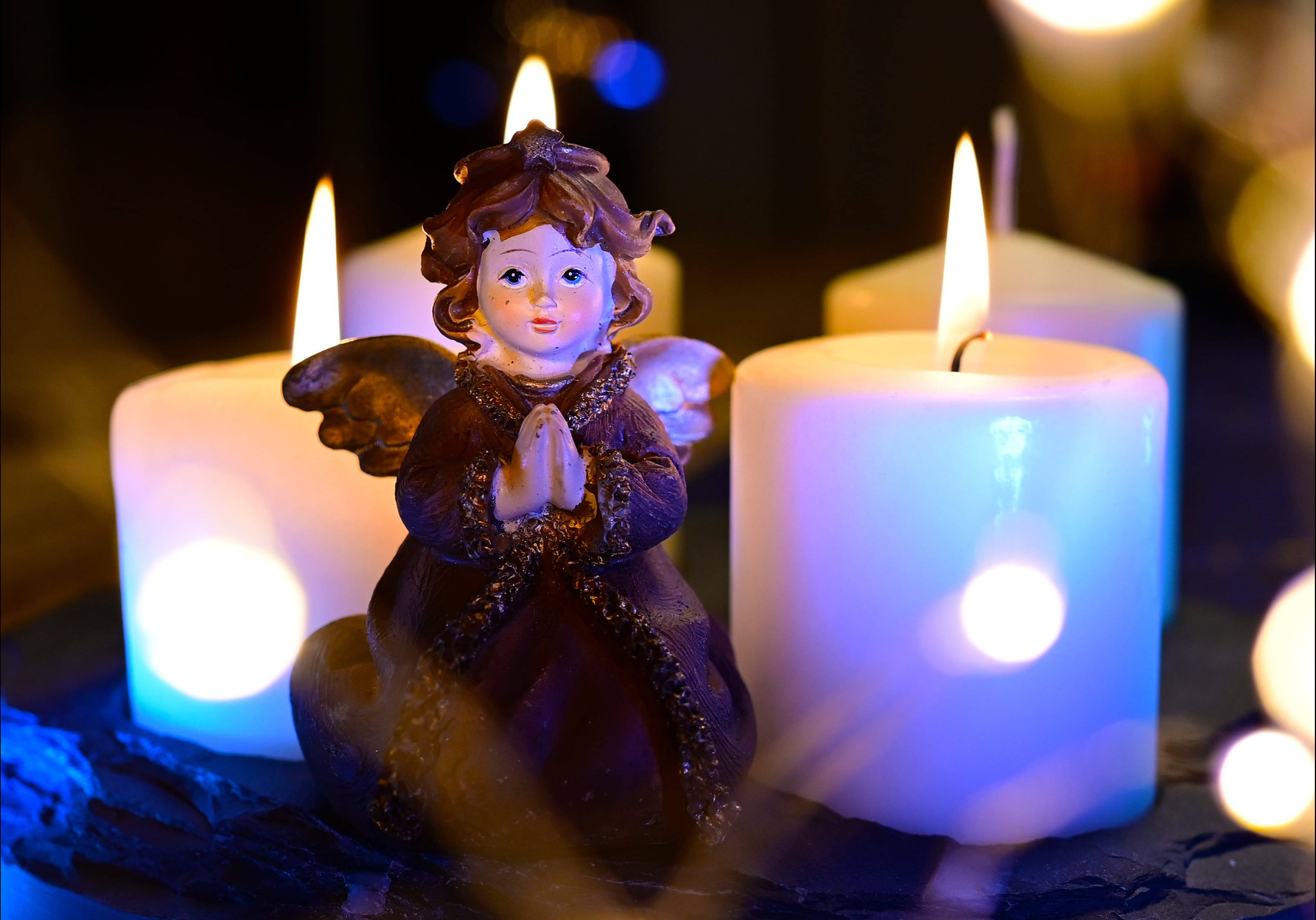 ملاك عيد الميلاد وشموع بيضاء خلفية