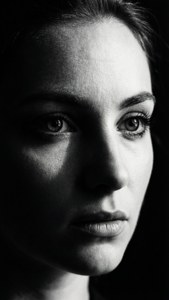 صورة شخصية بالأبيض والأسود مع ظلال دراماتيكية وعيون حادة.