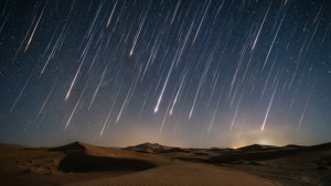 زخات شهب فوق كثبان رملية صحراوية تحت سماء ليلية مرصعة بالنجوم. — منظر السماء خلفية